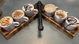 Hot Coffee Flights at Loco Espress shown on a Flight board wth 6 cups of different flavors.